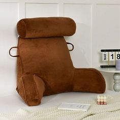 a large brown chair sitting on top of a white floor next to a table filled with toys