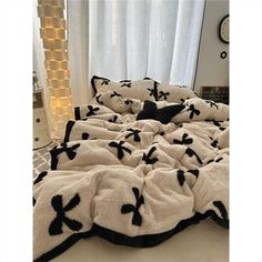 a black and white comforter with crosses on it is in front of a window