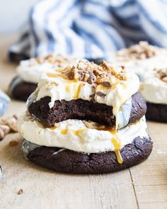 two cookies with ice cream and nuts on top are stacked up next to each other