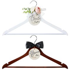 two wooden hangers with personalized tags on them and a flower in the middle