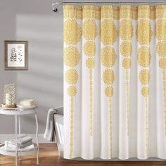 a shower curtain with yellow and white designs on it in a bathroom next to a bathtub