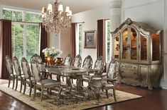 a dining room table with chairs and a chandelier in front of a large window