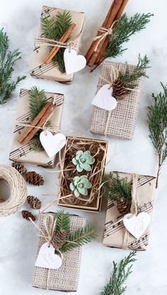 christmas presents wrapped in burlap and tied with twine, pine cones, cinnamon sticks, and evergreen needles