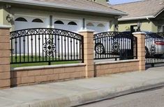 a house with a fence and cars parked in front of the gated entrance to it