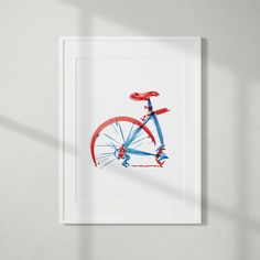 a red, white and blue bicycle is shown in a frame on the wall next to a window