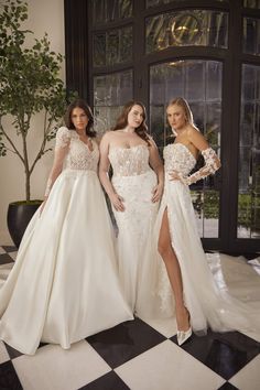 three women in wedding dresses standing next to each other on a black and white checkered floor