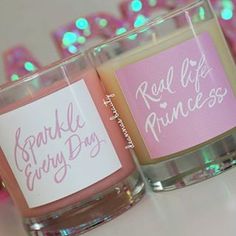 two candles with labels on them sitting next to each other