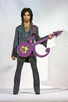 a man holding a purple guitar in his right hand