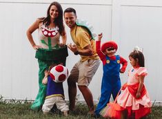 a group of people standing next to each other wearing costumes and posing for the camera