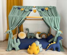 a child's bed with green drapes and blue curtains, stuffed animals on the floor