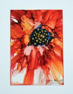 an orange and yellow flower is in a white frame with black dots on the center