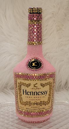 a bottle of hennesy pink wine with gold trimmings on the top