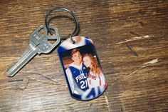 a keychain that has a picture of two people on it and is next to a pair of keys