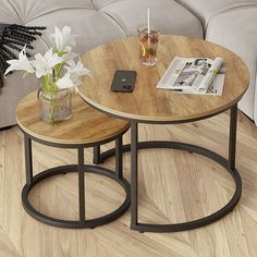 two tables sitting on top of a hard wood floor next to a couch and coffee table