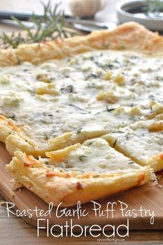 a close up of a pizza on a cutting board with cheese and herbs in the background