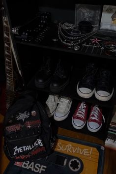 several pairs of shoes are sitting on the floor in front of a shelf with other items