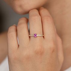 a woman's hand with a pink diamond ring