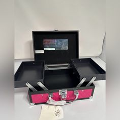 a pink and black suitcase sitting on top of a white table next to a pair of scissors