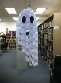 a room filled with lots of books and a light fixture made out of plastic cups