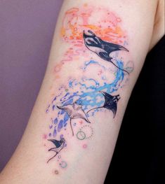 a woman's arm with three dolphins on it