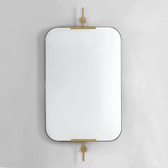 a mirror hanging on the wall with a gold bar around it's edge and an empty white square in the middle