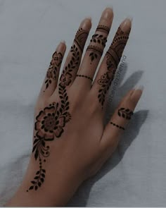 a woman's hand with henna tattoos on it