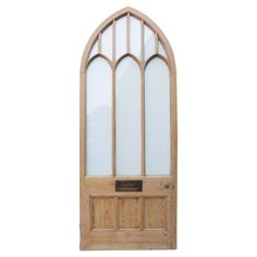 an arched wooden door with glass panels on the top and bottom panel, against a white background