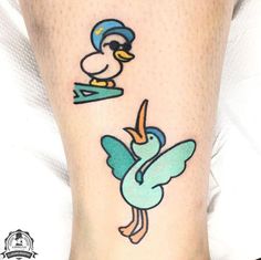 a small tattoo on the leg of a person with a bird and penguin in it