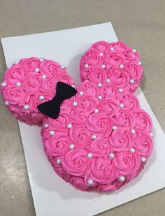 a cake shaped like mickey mouse with pink frosting