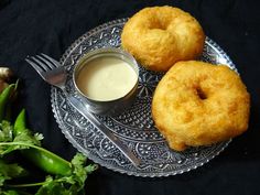 two doughnuts on a plate with dipping sauce