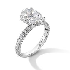 an oval cut diamond ring with pave set diamonds on the band and side stones