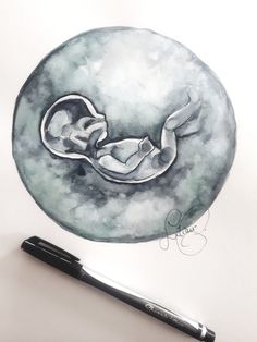 a drawing of a sleeping baby on the moon with a black ballpoint pen next to it