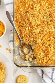 a casserole dish filled with macaroni and cheese next to crackers