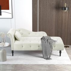 a white couch sitting on top of a rug in a living room