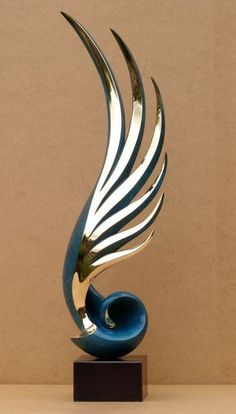 a blue and silver sculpture sitting on top of a wooden table next to a wall