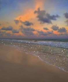 an ocean beach with waves coming in to the shore and colorful clouds above it at sunset