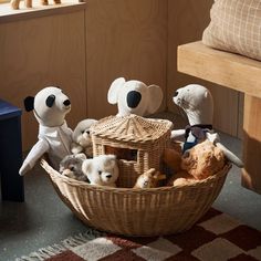 several stuffed animals in a basket on the floor