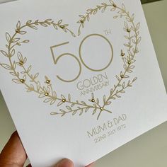 someone holding up a 50th anniversary card in their hand