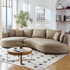 a living room with a large sectional couch and coffee table on the floor in front of it