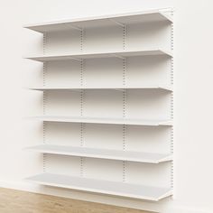 an empty white shelf in the corner of a room with wood flooring and wooden floors