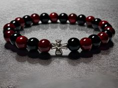 🌟 Introducing the Exquisite 7 3/4 Inch Red Dyed Quartz and Black Onyx Beaded Bracelet with Silver Cross 🌟 Elevate your style with our Stunning Beaded Bracelet, a true masterpiece crafted for those who appreciate the finer things in life. This 7 3/4 inch bracelet features a harmonious blend of Red Dyed Quartz and Black Onyx beads meticulously strung together, creating a stunning visual symphony that captivates the eye. ✨ Key Features: Radiant Red Dyed Quartz: Each bead is carefully dyed to enhance its natural beauty, radiating a warm and captivating hue that adds a touch of glamour to your wrist. Sleek Black Onyx: The Black Onyx beads bring a sense of mystery and sophistication to the bracelet, creating a striking contrast that makes a bold statement. Elegant Silver Cross: The centerpiece Radiant Red, Bracelet Ideas, Onyx Bead, Silver Spring, Silver Cross, Bead Bracelet, Black Onyx, Arm Band, Beaded Bracelet