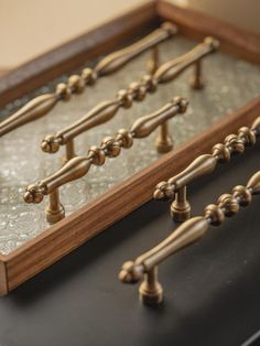 an old fashioned wooden and glass display case with brass knobs on the handles,