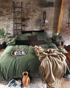 a bedroom with brick walls and green bedding