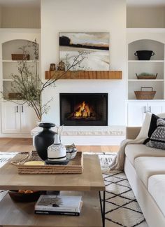 a living room filled with furniture and a fire place in the middle of the room