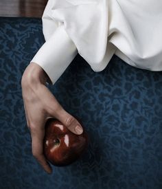 an apple being held by someone's hand on the floor in front of them