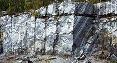 a large rock formation with trees in the background