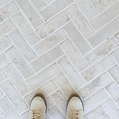 a pair of shoes sitting on top of a white tile floor