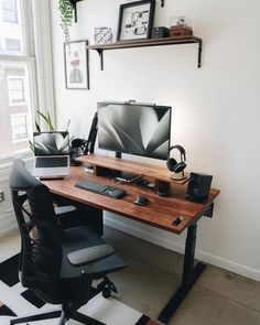 a desk with a computer on it in front of a window