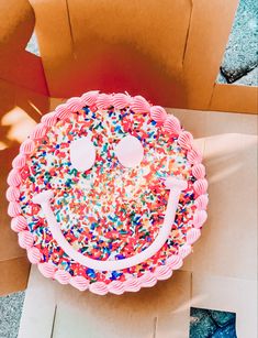 a birthday cake with sprinkles and a smiley face on it's side