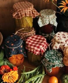 there are many jars and vegetables on the table